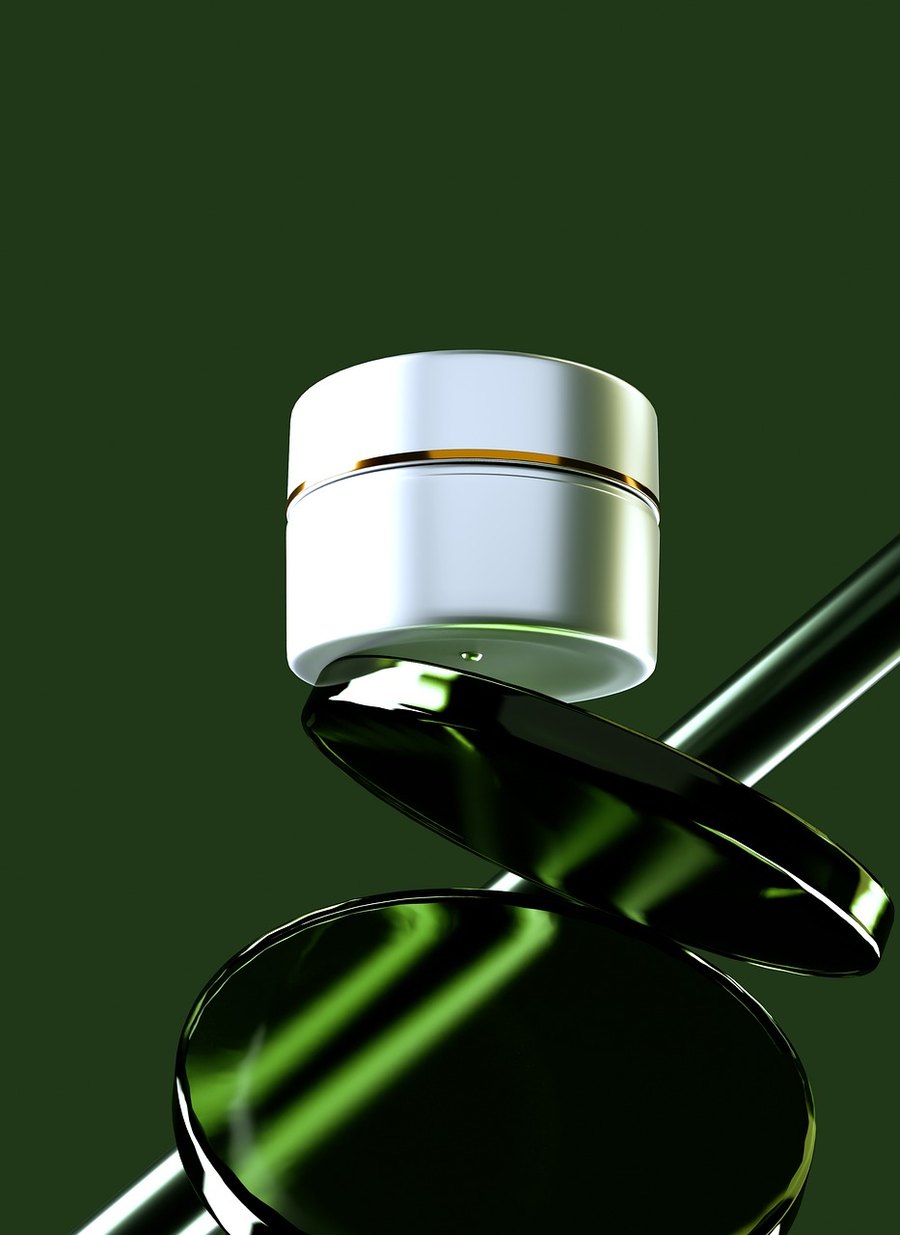 Frasco metálico de bálsamo sobre fondo verde (imagen de referencia)